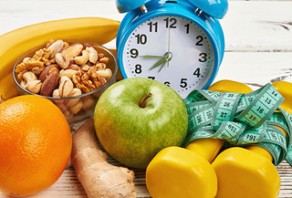 Various Fruits and Nuts with an Alarm Clock and Weights