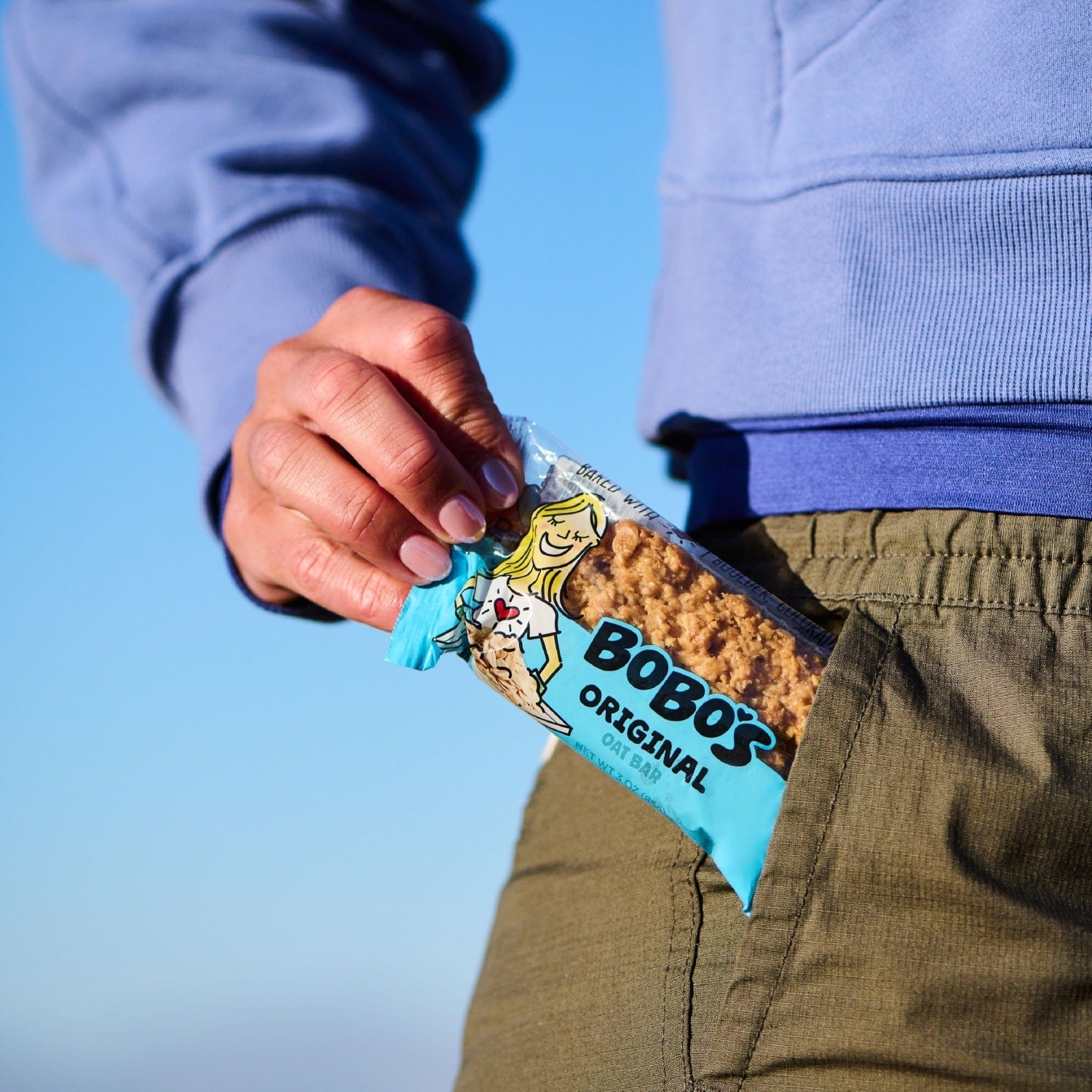 A person putting an Original Oat Bar in their pocket