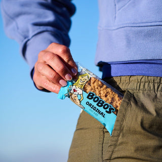A person putting an Original Oat Bar in their pocket