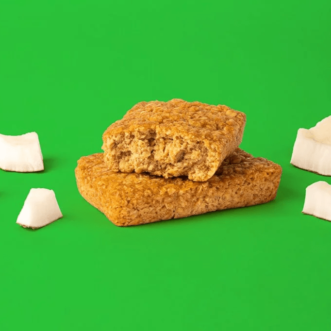 Bobo's Coconut Oat Bar split in half on a green background