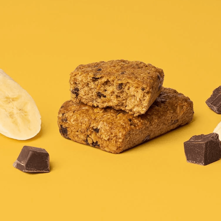Bobo's Banana Chocolate Chip Oat Bar split in half on a burnt yellow background