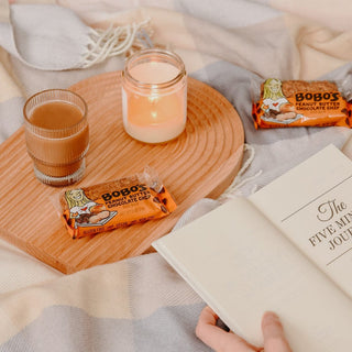 Oat bars on a table with a candle and a beverage