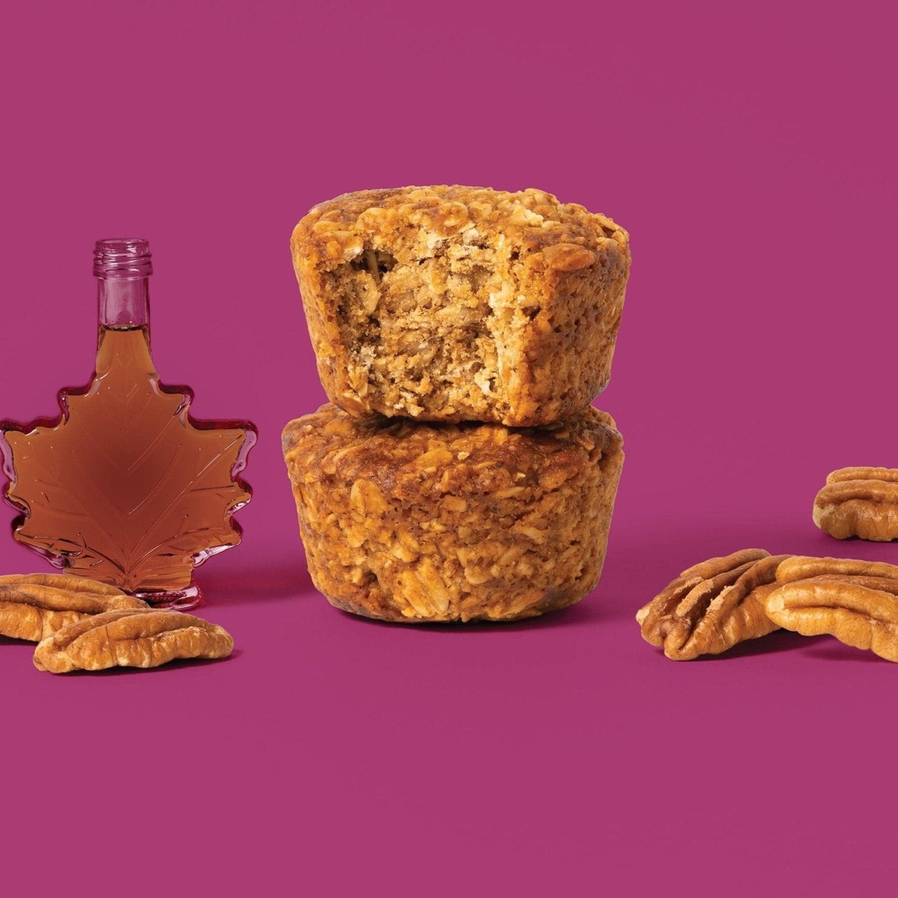 Oat bite on purple background with surrounding pecans and maple syrup