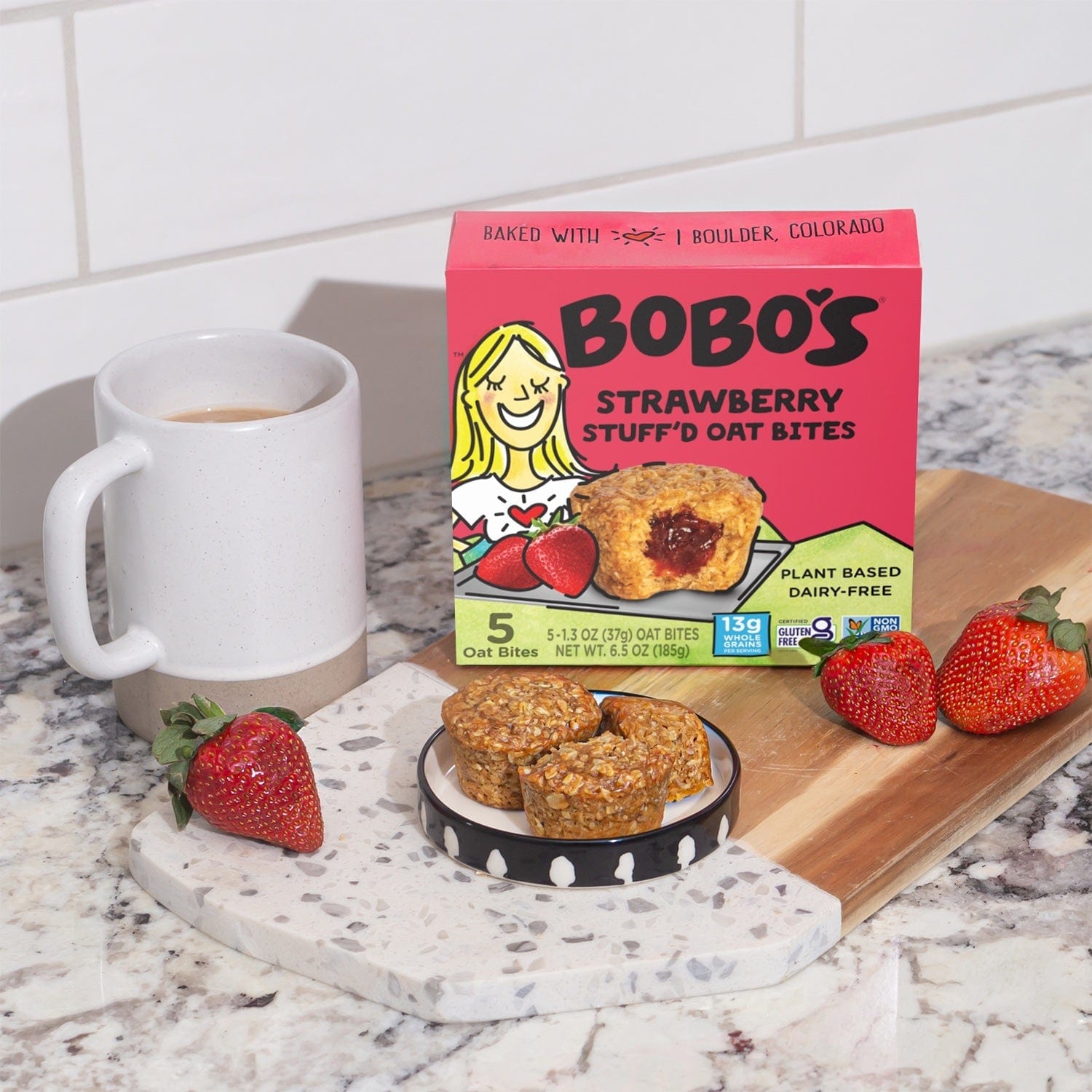 Oat bite on pink background with surrounding strawberries