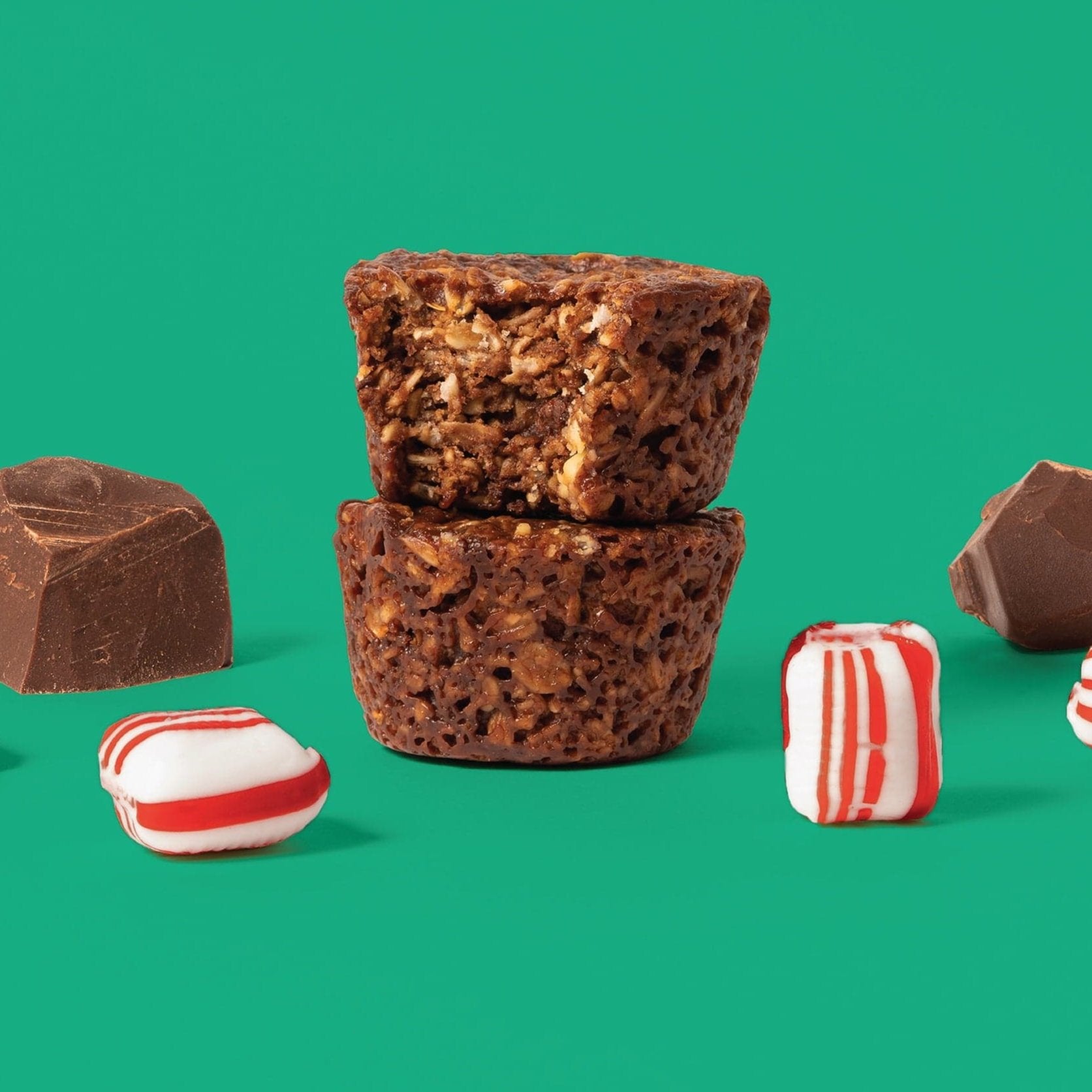 Oat bite on green background with surrounding peppermints and chocolate chunks