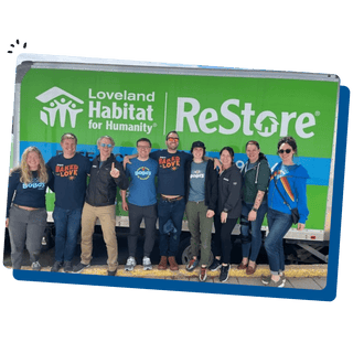 Bobo's team members standing behind a Loveland Habitat for Humanity billboard