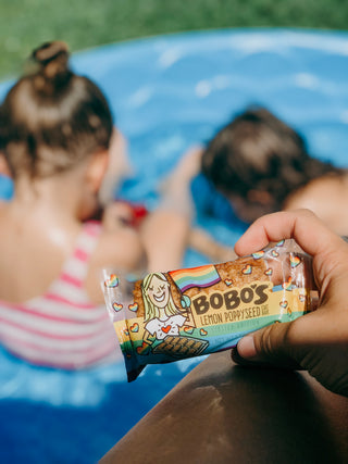 Fun summer activities outdoor. Sitting in a pool and eating Bobo's Oat Bars
