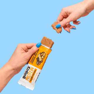 Piece of Bobo's Peanut Butter Chocolate Chip protein bar being broken off