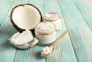 Coconut oil and coconut on a blue wooden table
