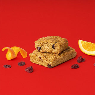 A close-up of a Cranberry Orange Oat Bar with raisins, orange peels, and wholesome whole grain oats.
