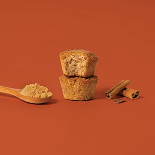Oat bite on brown background with surrounding ginger and cinnamon