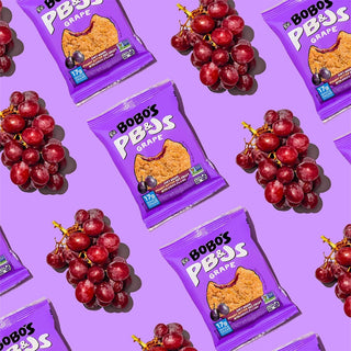 PB&J oat snack on purple background with surrounding grapes and peanut butter
