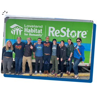 Bobo's team members standing behind a Loveland Habitat for Humanity billboard