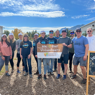 Bobo's team members holding a sign that says "we love our volunteers" for growing gardens